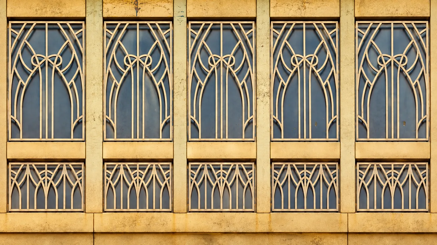 Tall arched windows in gold and green glass, an Art Deco motif